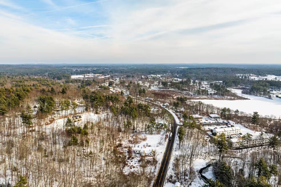 Aerial Winter Snow Rural Road Bare Trees in Raymond, NH